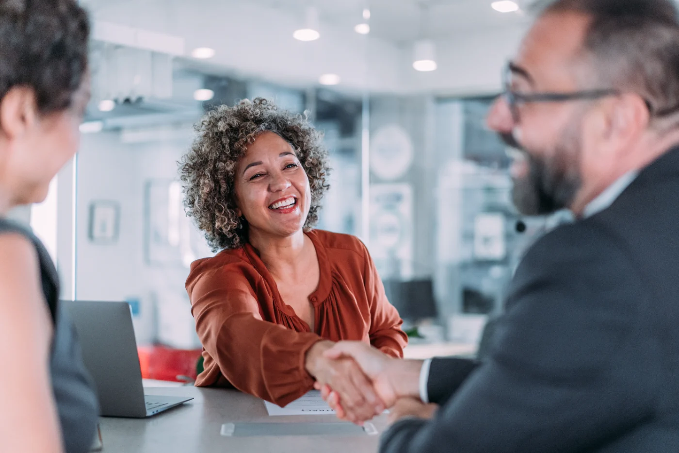 Conseillère et client se serrant la main lors d'une rencontre – une approche humaine et sans jugement
