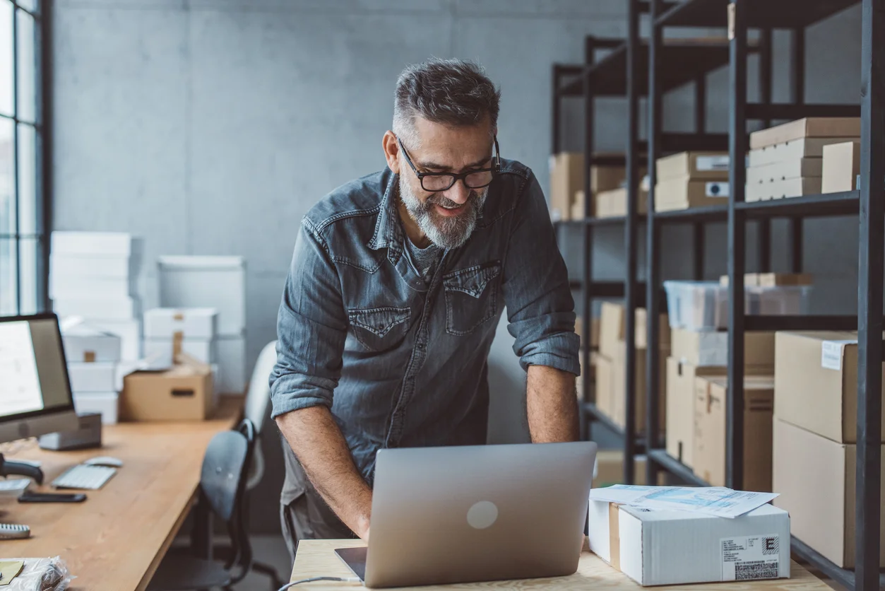 Propriétaire de PME faisant le point sur son ordinateur dans son atelier – redressement d'entreprise