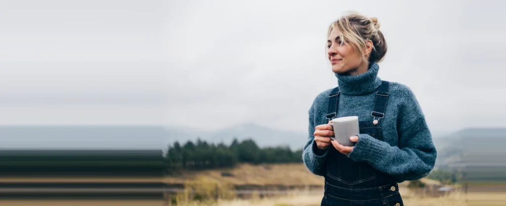 Femme sereine à l'extérieur au lever du jour, symbole d'un nouveau départ financier