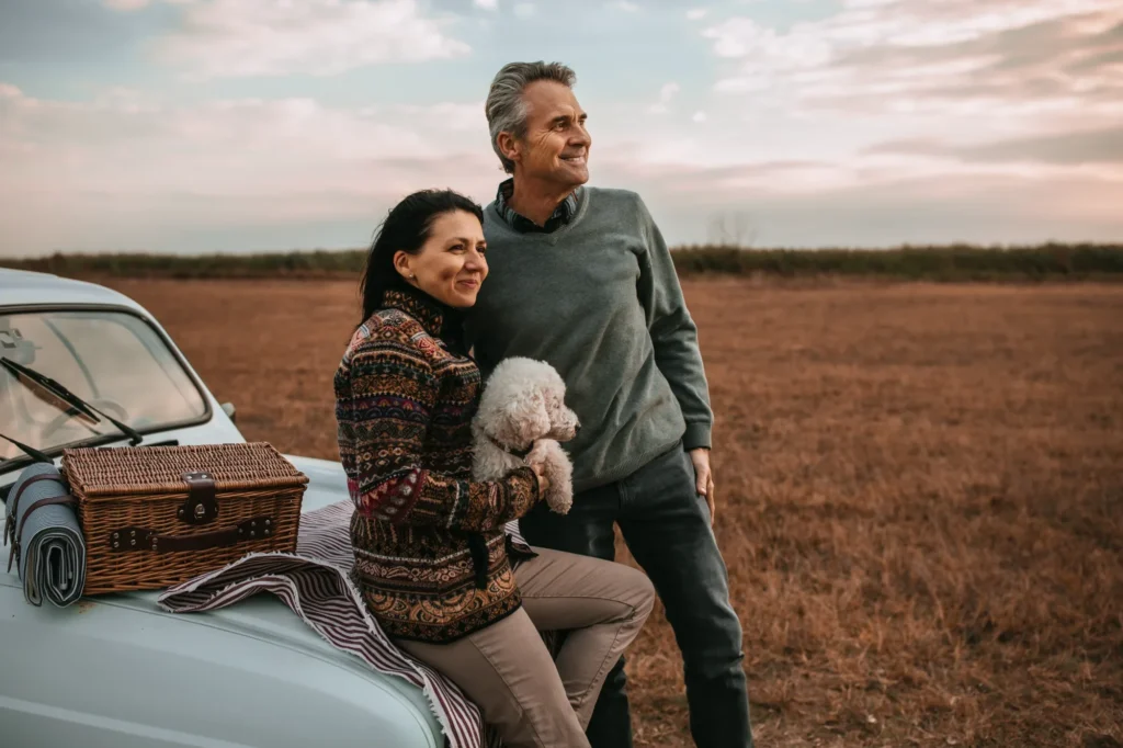 Couple souriant à l'extérieur au coucher du soleil – régler ses dettes ensemble avec une proposition conjointe