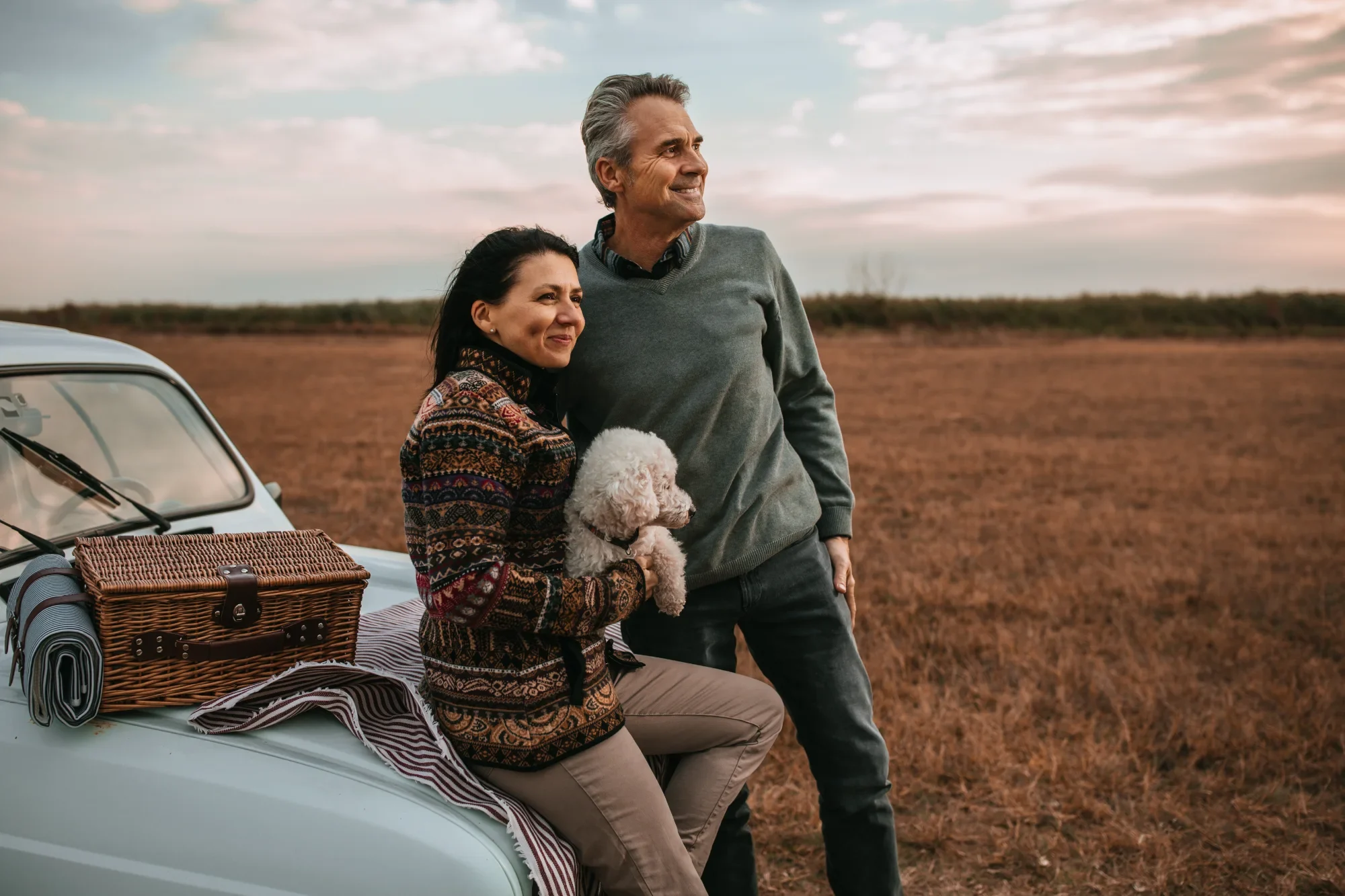 Couple souriant à l'extérieur au coucher du soleil – régler ses dettes ensemble avec une proposition conjointe