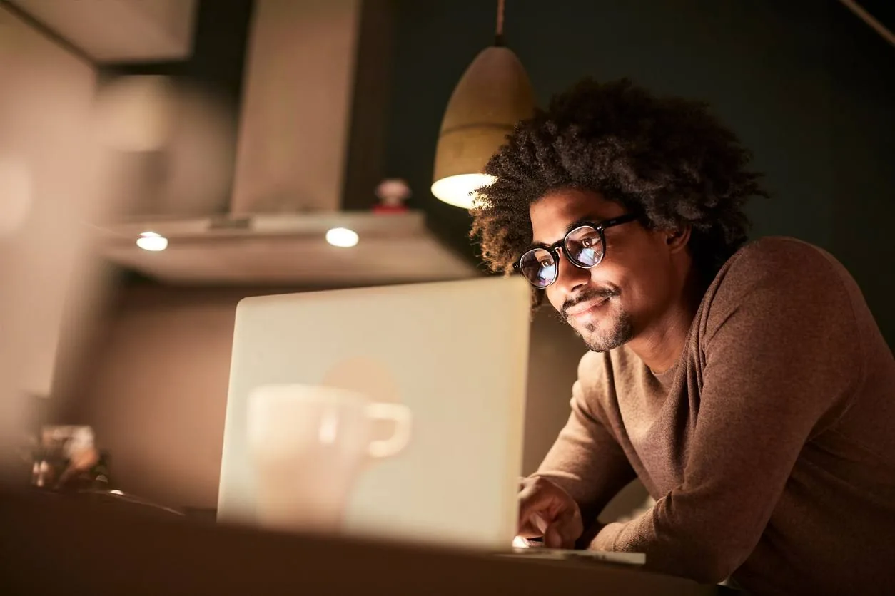 Homme concentré devant son ordinateur en soirée — faire le point sur son budget