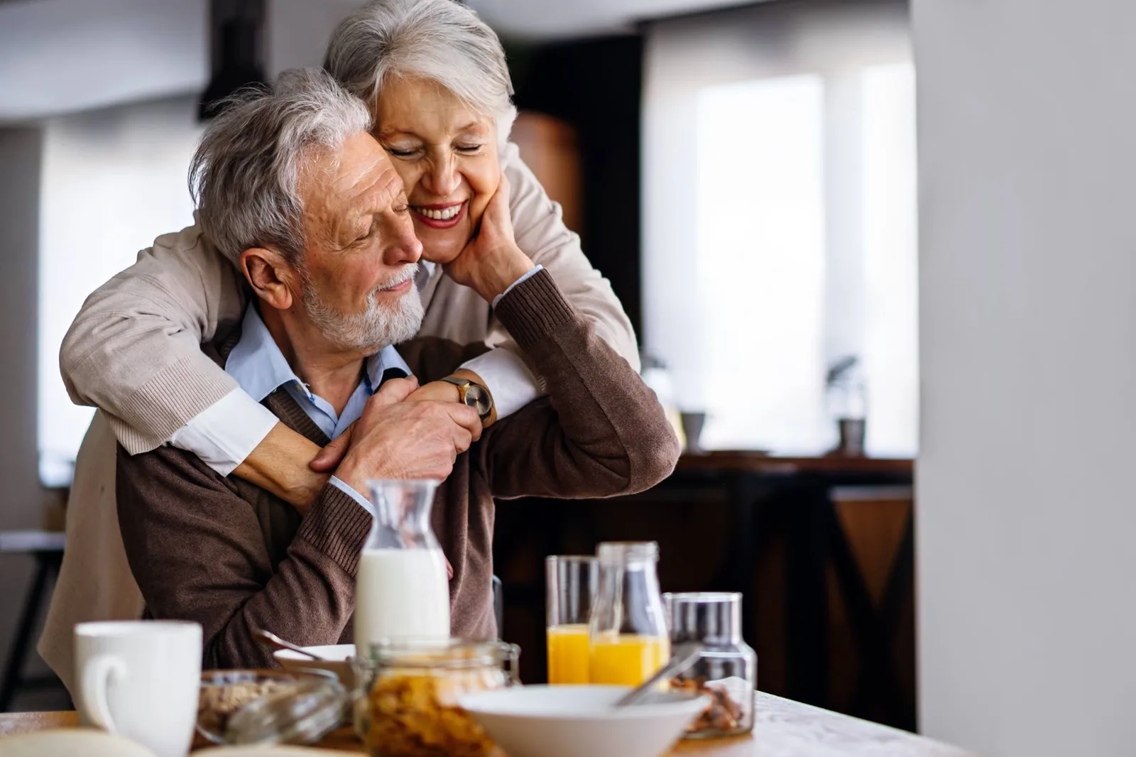 Couple d'aînés qui s'enlace tendrement au déjeuner — une retraite plus légère