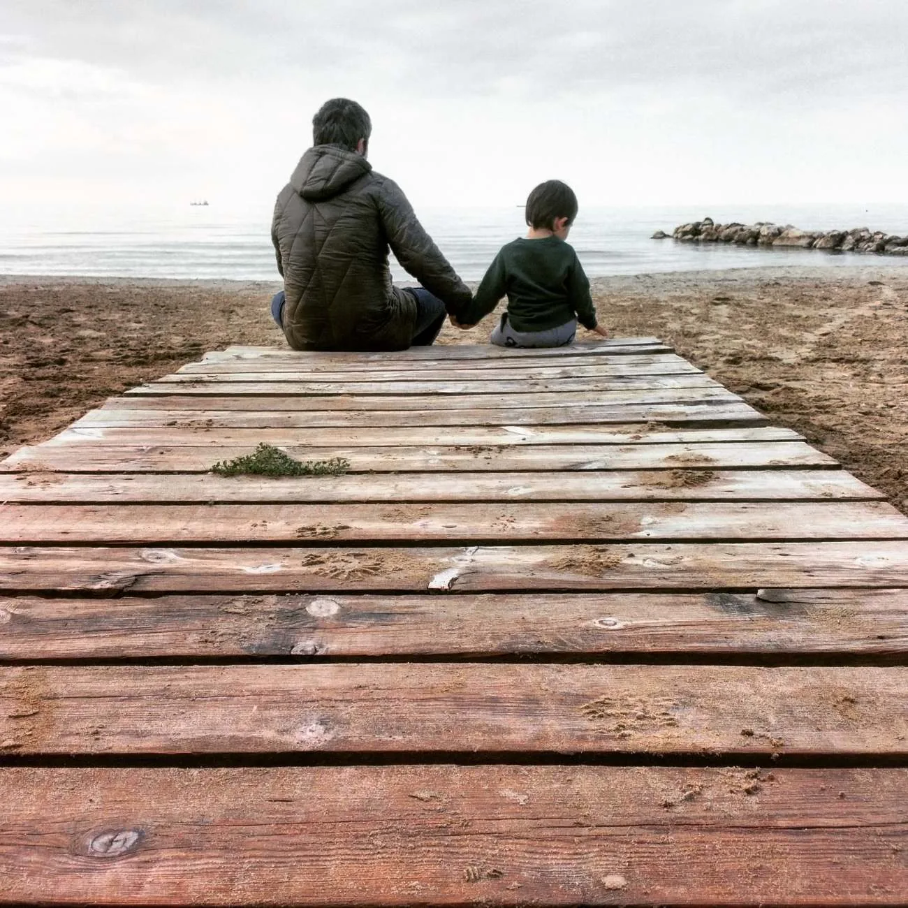 Un parent et son enfant assis face à la mer — protéger l'essentiel pendant une séparation