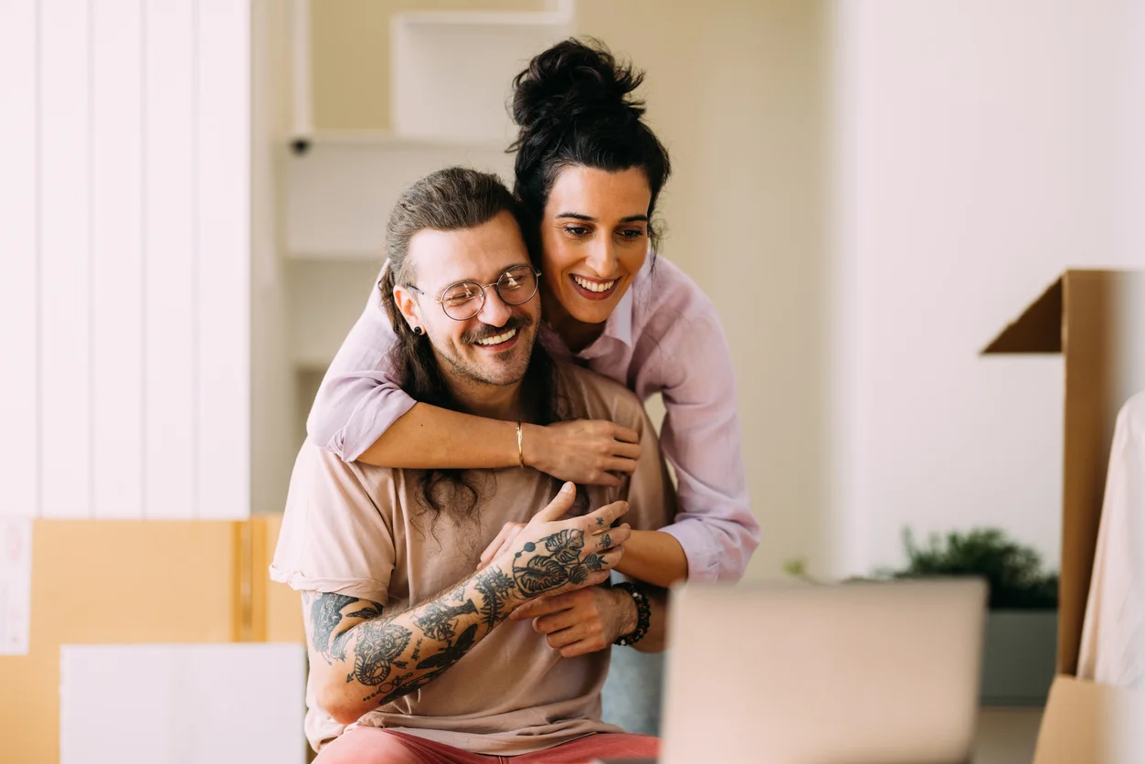Maxime et sa conjointe, souriants dans leur logement – photo d'illustration - dettes de carte de crédits